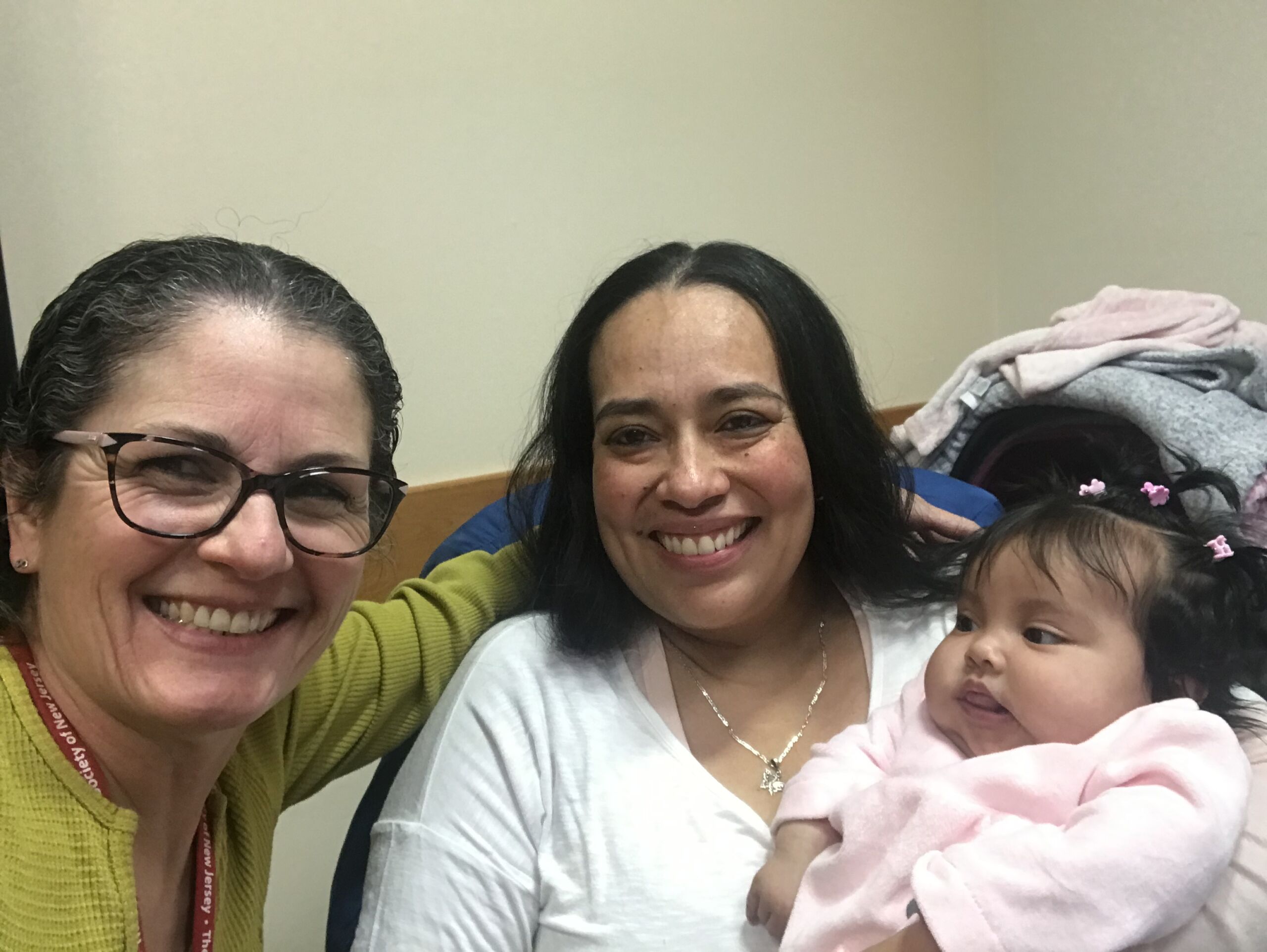 AMAR Doula supervisor posing with a mother served by a AMAR and her child.